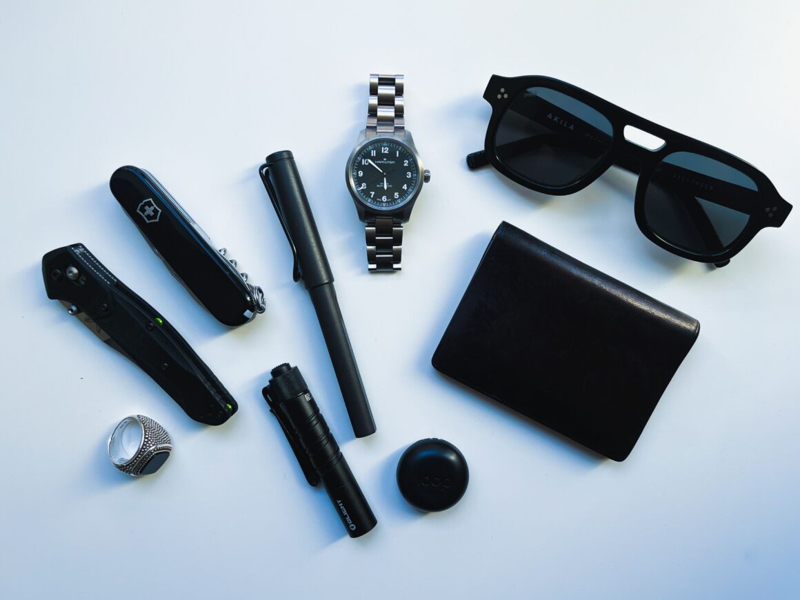 A pocket dump flatlay of minimalist, all-black EDC gear
