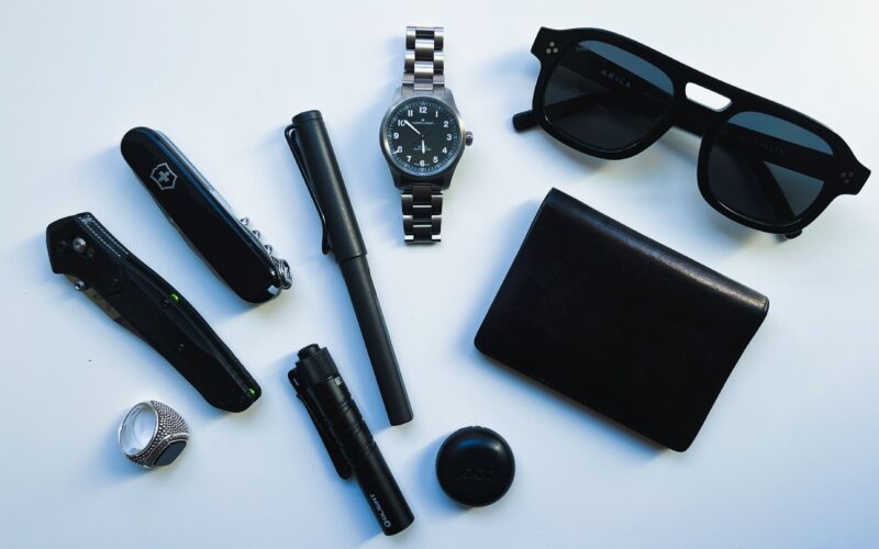 A pocket dump flatlay of minimalist, all-black EDC gear